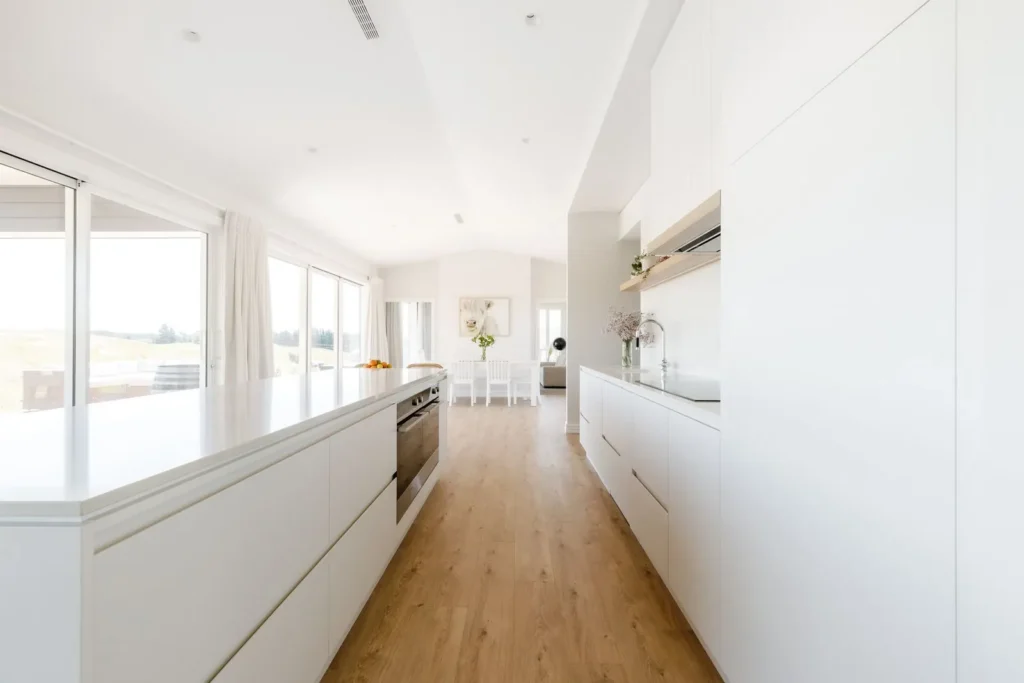 Long white kitchen with timber floors at Redvale Estate